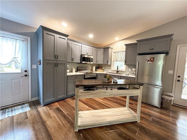 58 E Sugar Lake Cv, Mound City, KS 66056 - kitchen featuring a sink, appliances with stainless steel finishes, gray cabinetry, light countertops, and vaulted ceiling