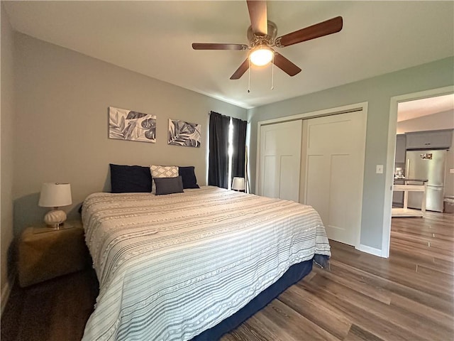58 E Sugar Lake Cv, Mound City, KS 66056 - bedroom featuring freestanding refrigerator, a closet, baseboards, a ceiling fan, and dark wood-type flooring