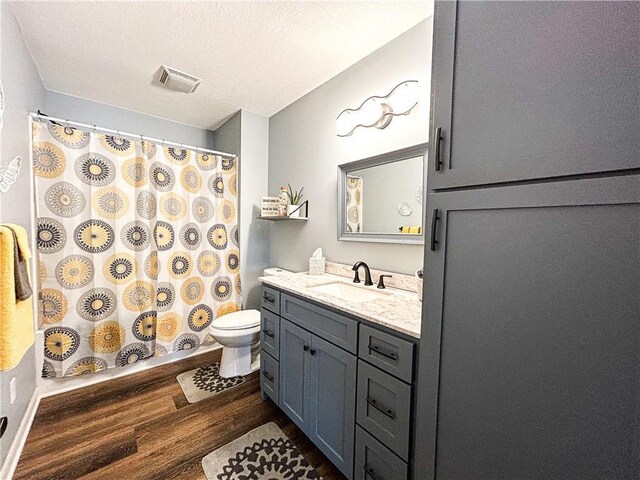 58 E Sugar Lake Cv, Mound City, KS 66056 - bathroom featuring wood finished floors, toilet, vanity, baseboards, and visible vents