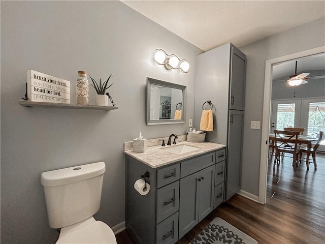 58 E Sugar Lake Cv, Mound City, KS 66056 - bathroom featuring vanity, toilet, a ceiling fan, baseboards, and wood finished floors