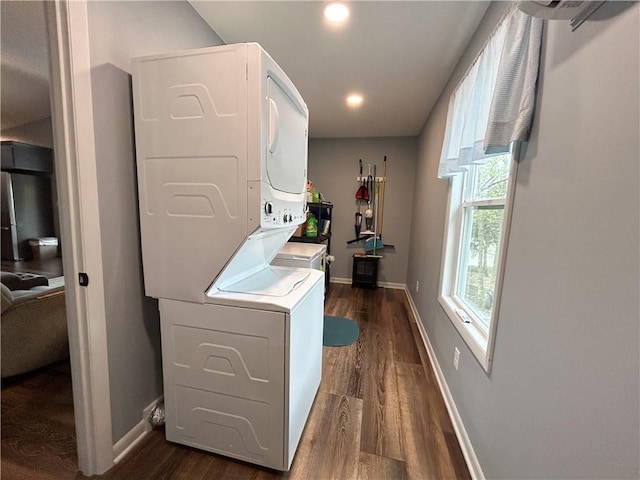 58 E Sugar Lake Cv, Mound City, KS 66056 - laundry room featuring stacked washer / drying machine, dark wood-style floors, laundry area, and baseboards