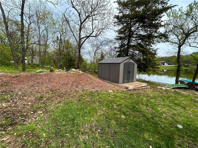 58 E Sugar Lake Cv, Mound City, KS 66056 - view of yard with a storage shed, a water view, and an outbuilding