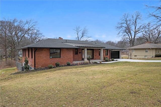 view of front of house with a front lawn, concrete driveway, brick siding, and a garage