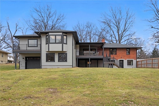 rear view of house with a lawn, stairway, a balcony, and fence