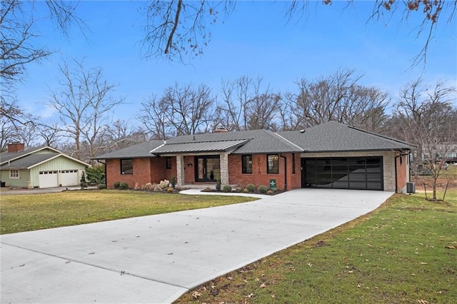 view of front facade with concrete driveway, a chimney, a front yard, an attached garage, and brick siding