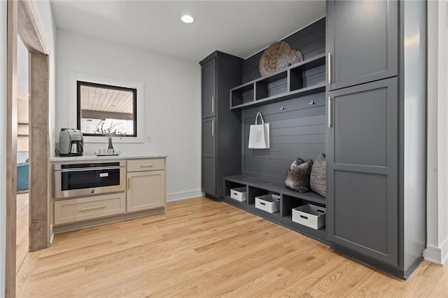 mudroom with baseboards, recessed lighting, and light wood finished floors