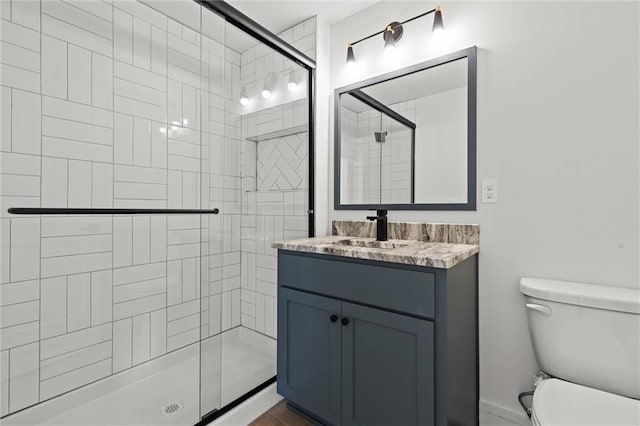 bathroom featuring vanity, toilet, and a stall shower