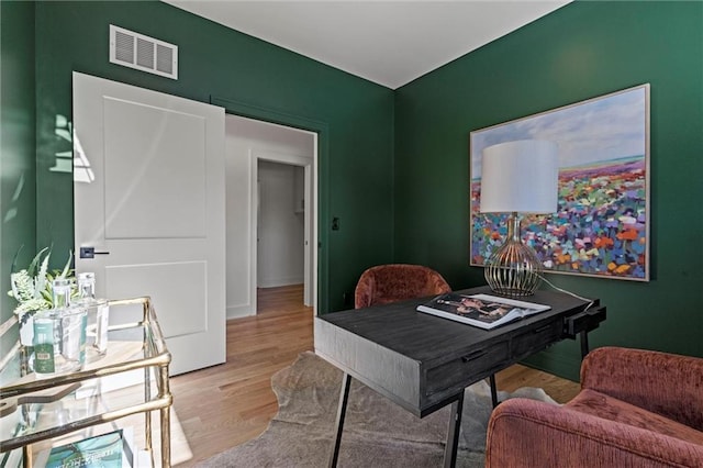 office area featuring wood finished floors, visible vents, and baseboards