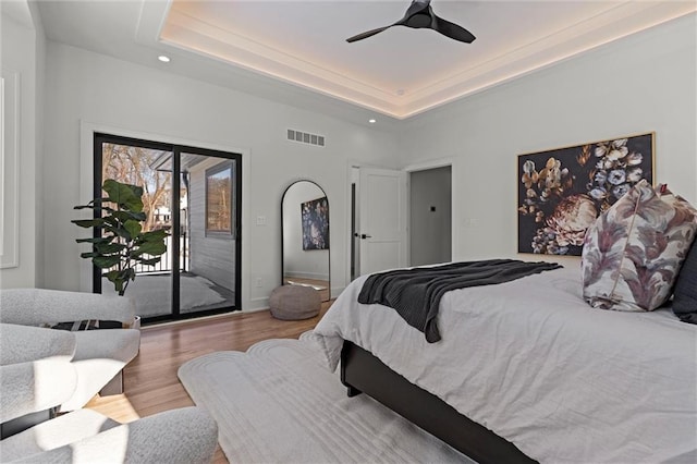bedroom with wood finished floors, visible vents, recessed lighting, and access to exterior