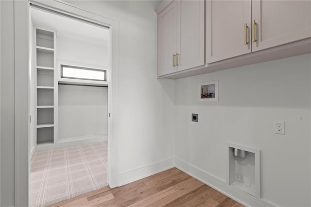 laundry area featuring light wood finished floors, cabinet space, electric dryer hookup, hookup for a washing machine, and baseboards