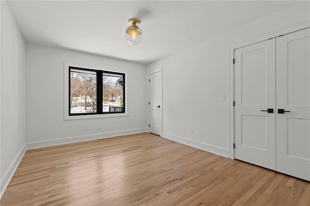 unfurnished bedroom featuring baseboards and light wood-type flooring