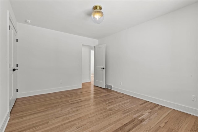 unfurnished room with baseboards, visible vents, and light wood finished floors