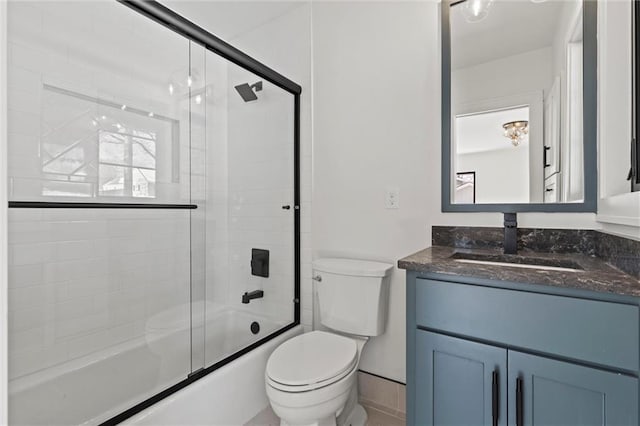full bathroom featuring toilet, enclosed tub / shower combo, and vanity