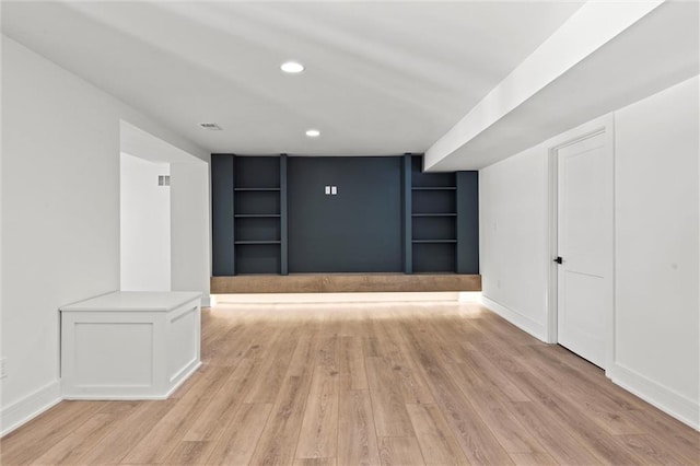 interior space with baseboards, light wood-style floors, and built in features