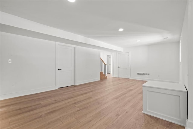 basement featuring stairway, visible vents, light wood-style floors, baseboards, and recessed lighting