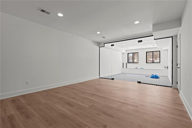 interior space with baseboards, visible vents, light wood-style flooring, and recessed lighting