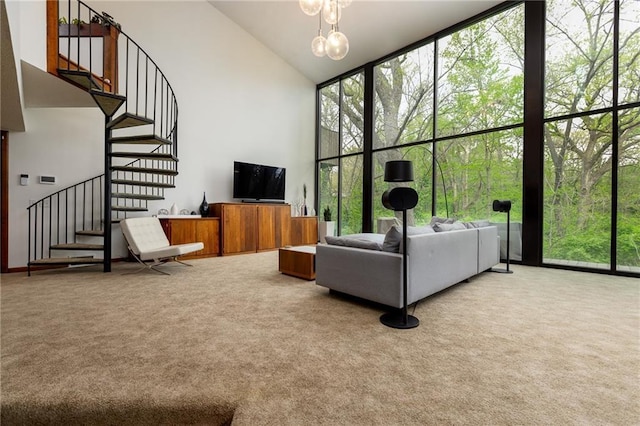 living area with high vaulted ceiling, a healthy amount of sunlight, stairway, and carpet