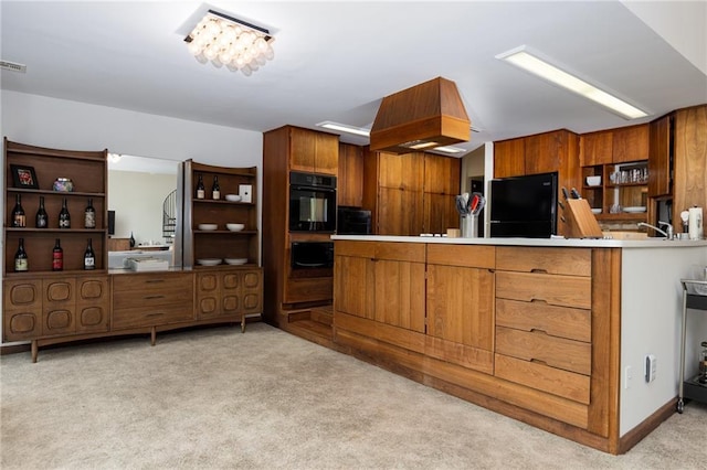 kitchen featuring brown cabinetry, freestanding refrigerator, and light colored carpet