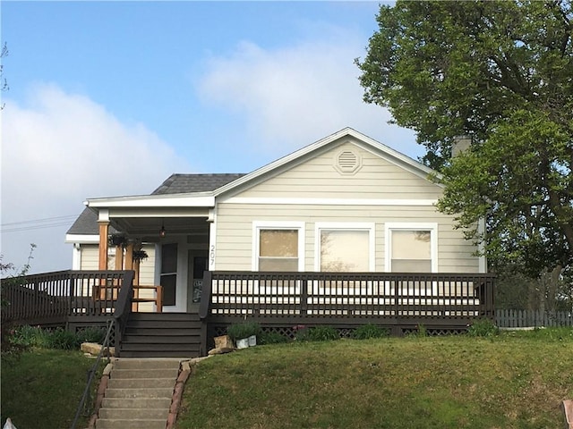 bungalow featuring stairs, a front lawn, and covered porch