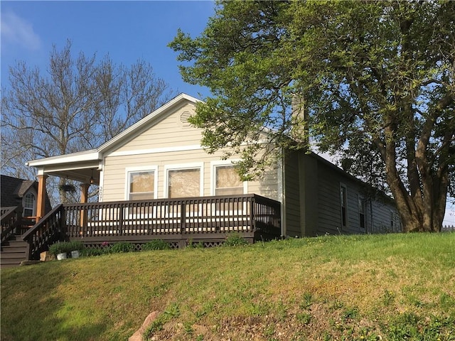 back of house featuring a yard and a deck