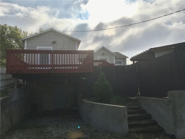 back of house with fence and a wooden deck