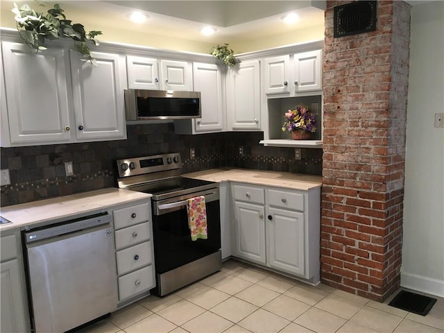 kitchen with stainless steel appliances, visible vents, decorative backsplash, and light tile patterned floors