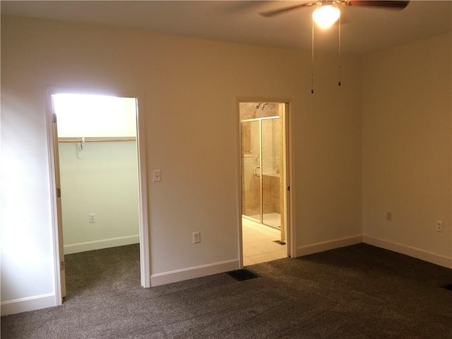 unfurnished bedroom with carpet flooring, a spacious closet, connected bathroom, and a closet