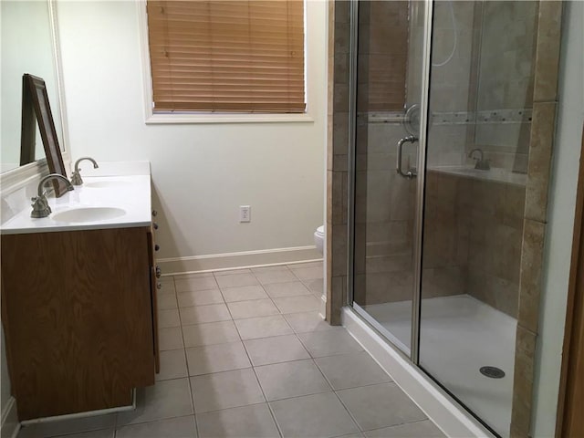 bathroom with baseboards, tile patterned floors, a shower stall, and a sink