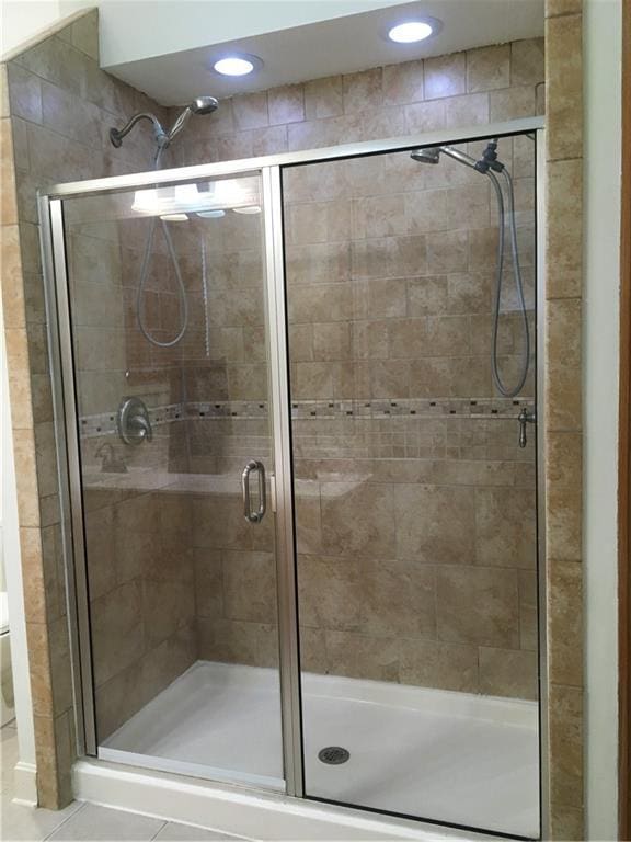 bathroom with recessed lighting, a shower stall, and tile patterned flooring