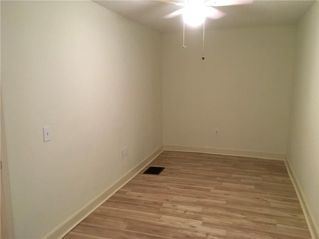 empty room featuring a ceiling fan, baseboards, visible vents, and light wood finished floors