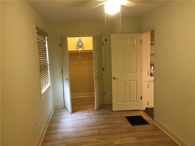 unfurnished bedroom with a ceiling fan, visible vents, baseboards, a closet, and light wood finished floors