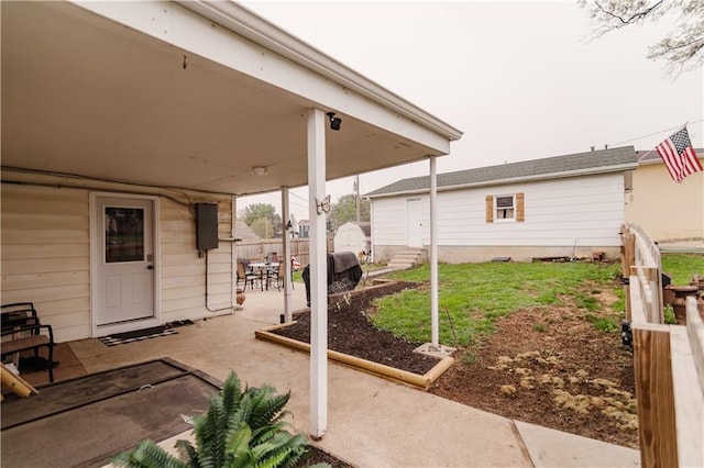 view of patio / terrace with fence, an outdoor structure, and a storage shed