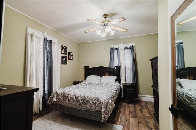 bedroom with crown molding, baseboards, and dark wood finished floors