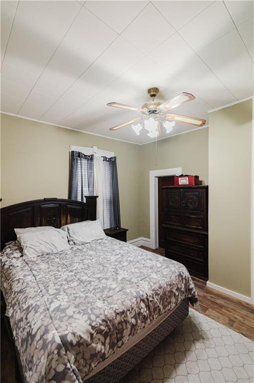 bedroom with baseboards, ceiling fan, and wood finished floors