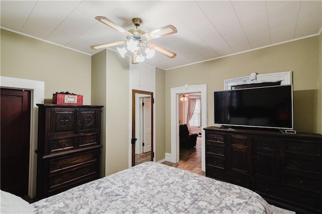 bedroom featuring ornamental molding, ceiling fan, and wood finished floors