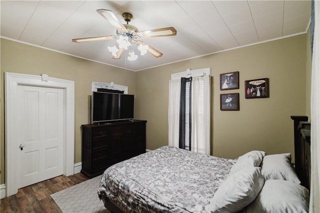 bedroom with crown molding, ceiling fan, and dark wood-style flooring