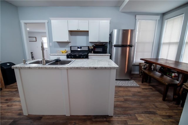 kitchen featuring dark wood-type flooring, a sink, white cabinets, and stainless steel appliances