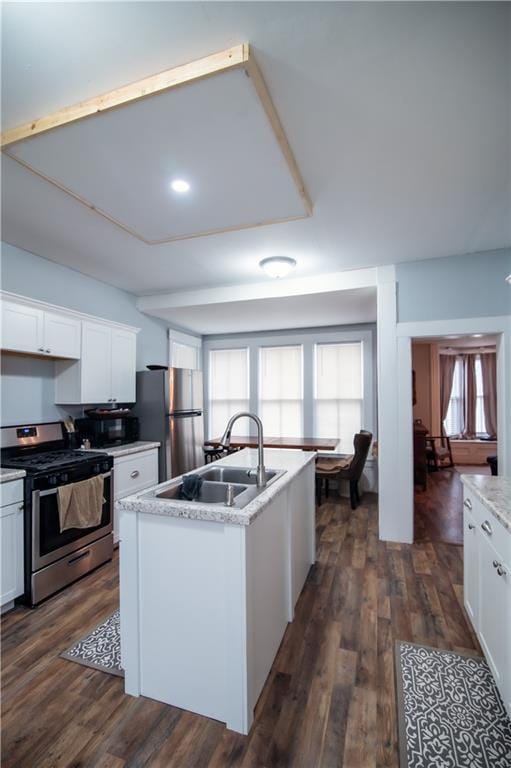 kitchen featuring a sink, appliances with stainless steel finishes, dark wood finished floors, and white cabinetry