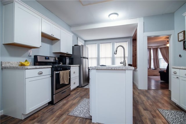 kitchen featuring a kitchen island, white cabinetry, appliances with stainless steel finishes, and dark wood-style floors