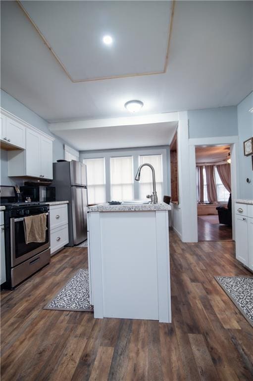kitchen with stainless steel appliances, dark wood-style floors, white cabinetry, and a sink
