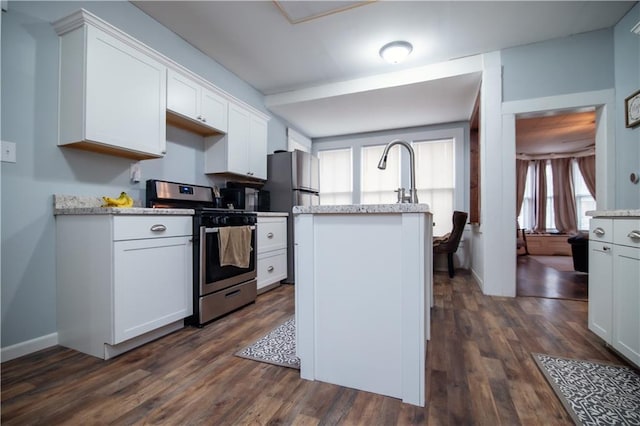 kitchen with a center island with sink, dark wood-style flooring, white cabinets, and stainless steel appliances