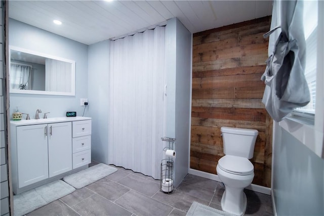 bathroom featuring vanity, wood walls, recessed lighting, and toilet