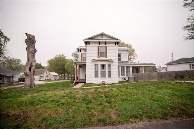 view of front of home with a front lawn, fence, and cooling unit