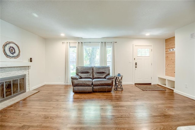 7636 Windsor St, Prairie Village, KS 66208 - living area featuring wood finished floors, a stone fireplace, baseboards, and recessed lighting
