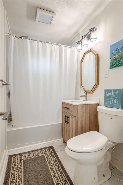 7636 Windsor St, Prairie Village, KS 66208 - full bathroom with toilet, vanity, and shower / tub combo with curtain