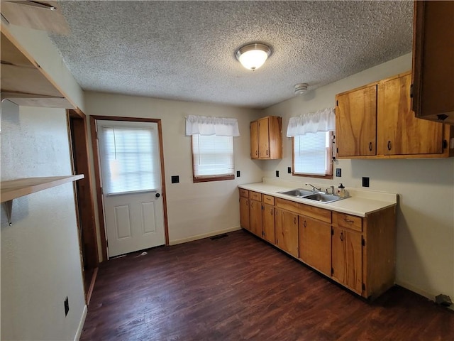 601 S 24th St, Lexington, MO 64067 - kitchen featuring a textured ceiling, a sink, light countertops, dark wood-style flooring, and brown cabinetry