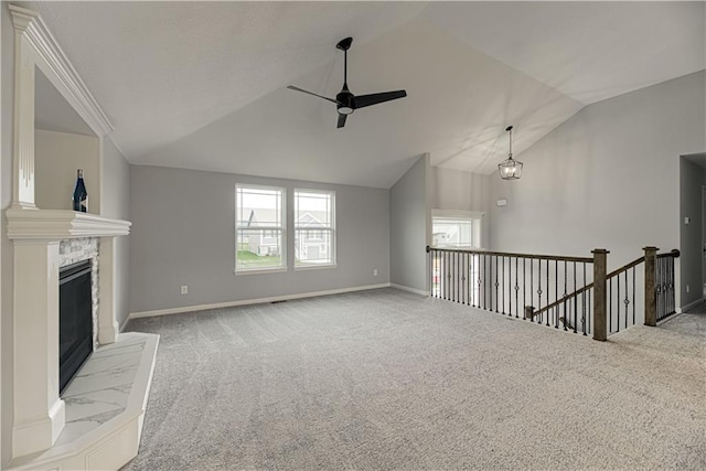 11802 N Bellaire Ave, Kansas City, MO 64156 - unfurnished living room featuring a ceiling fan, lofted ceiling, carpet, a stone fireplace, and baseboards