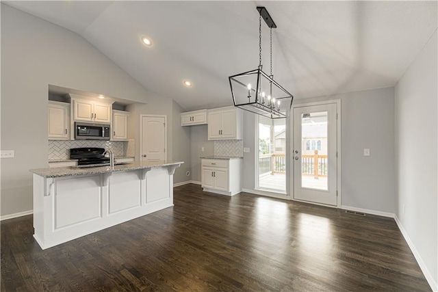 11802 N Bellaire Ave, Kansas City, MO 64156 - kitchen featuring stainless steel microwave, lofted ceiling, decorative backsplash, light stone counters, and stove