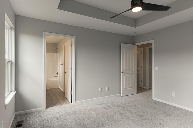 11802 N Bellaire Ave, Kansas City, MO 64156 - unfurnished bedroom with carpet, baseboards, a raised ceiling, and connected bathroom