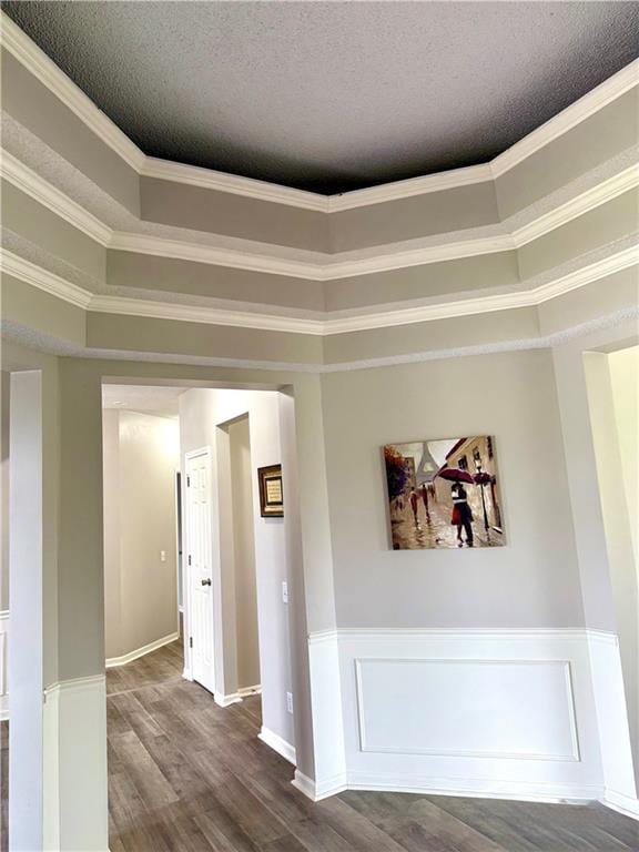 9201 N Harrison St, Kansas City, MO 64155 - spare room with dark wood-style flooring, a textured ceiling, ornamental molding, a wainscoted wall, and baseboards